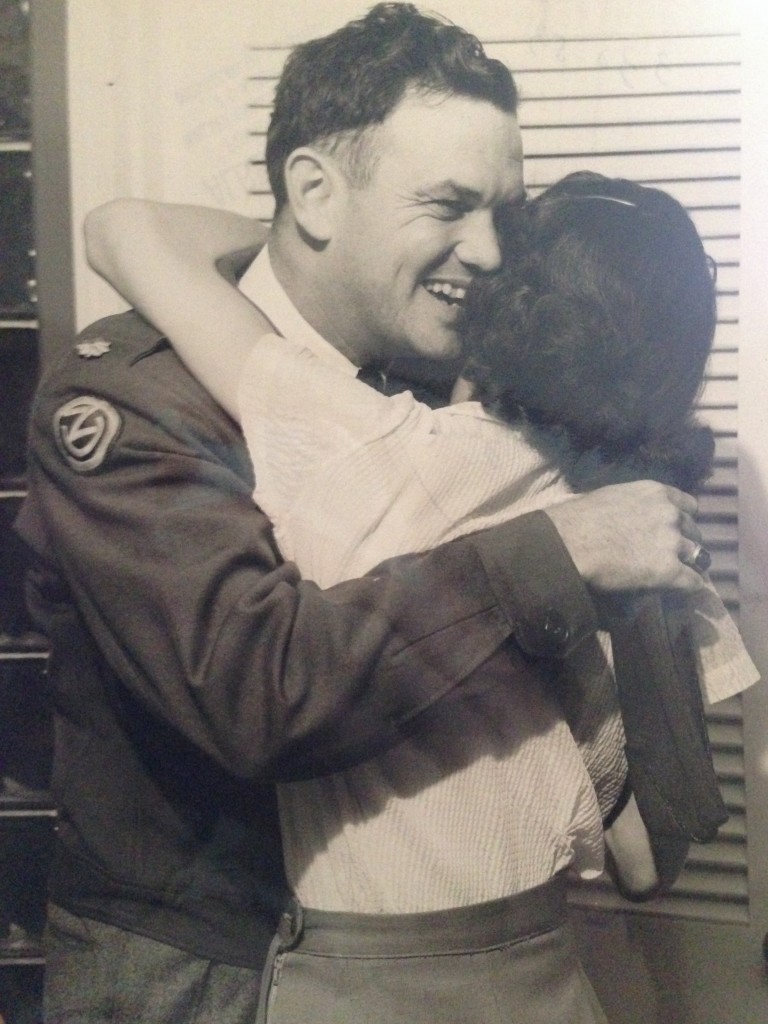 A man in a military uniform hugging a woman